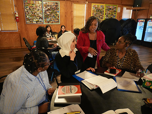 Dr Hall talking to a table of participants