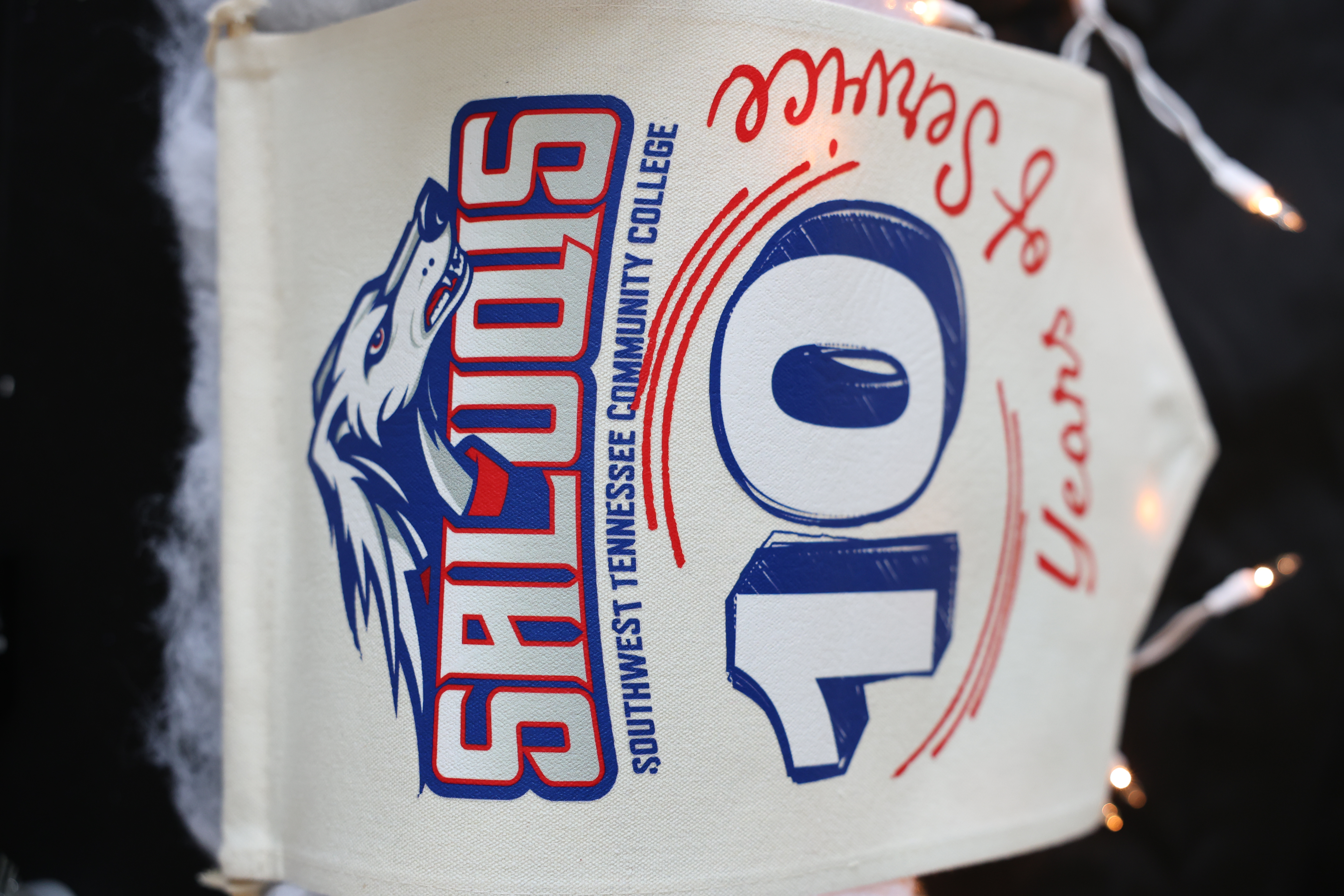 Banner with "SALUQIS Southwest Tennessee Community College" at top, stylized wolf image, "10 Years of Service" below, festive and celebratory tone.